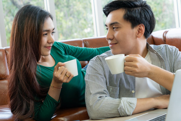 快乐的亚洲夫妇在家喝咖啡图片下载