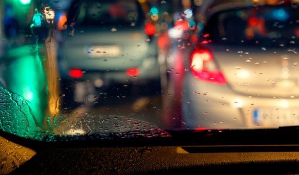 雨点落在汽车挡风玻璃上，在雨天的驾驶条件下图像模糊图片下载