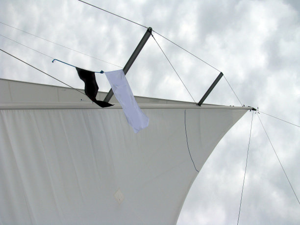 一种帆船的桅杆，帆和缆绳上挂着海盗旗图片下载