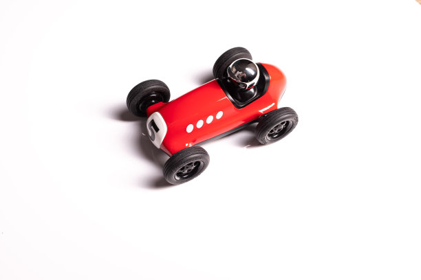 红色玩具赛车上画着五号，银色的头盔孤立在白色的背景上图片下载