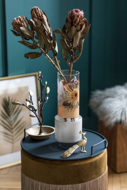 时尚和花卉组成的美丽的花在现代花瓶上天鹅绒蒲团与优雅的配件和家具。客厅的花朵概念。绿色的墙。室内设计模板图片下载