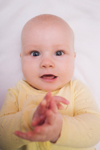 小婴儿宝宝正躺在床上，拍拍手合上图片下载