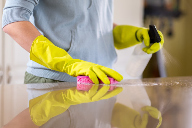 正在用消毒剂和海绵消毒柜台的妇女图片下载