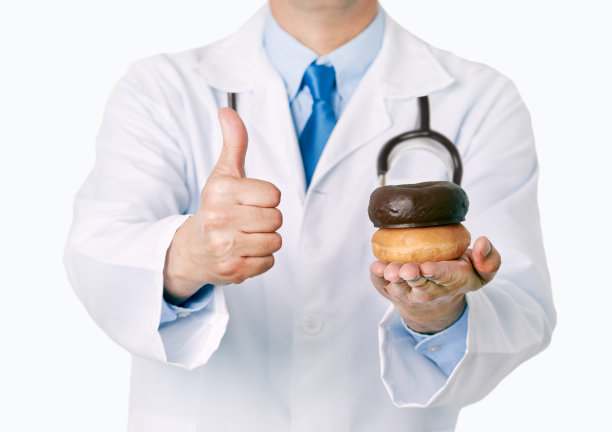 一个医生手里拿着白色背景的甜甜圈图片下载