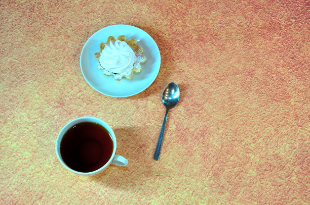 一杯红茶和一个盘子，上面有一个奶油酥饼篮子。图片下载