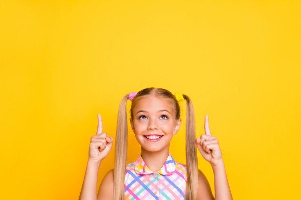 购物心情好的快乐小女孩指着空白区域图片下载