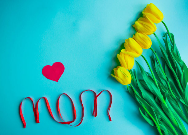 母亲节快乐贺卡与一束美丽的春天的黄色郁金香花在浅蓝色的背景。平的概念。图片下载