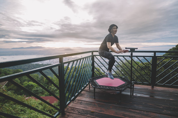 亚洲华人体育运动员迷你蹦床晨曦中在槟城山上锻炼图片下载