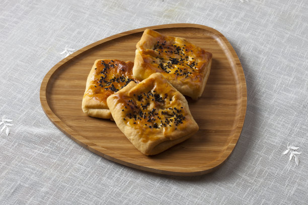 木盘上刚烤好的自制小圆面包。水平特写白色背景。图片下载