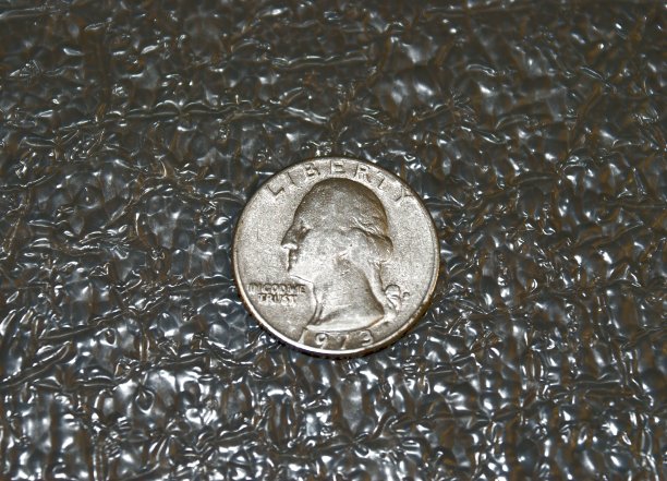 四分之一美元硬币躺在发光的灰色背景上。图片下载