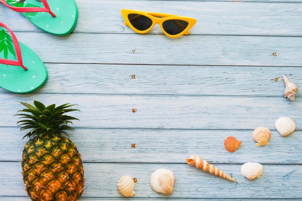 顶视图有趣的菠萝海贝壳戴着红色太阳镜，凉鞋和帽子在蓝色的木制背景与复制空间暑假和度假概念。图片下载