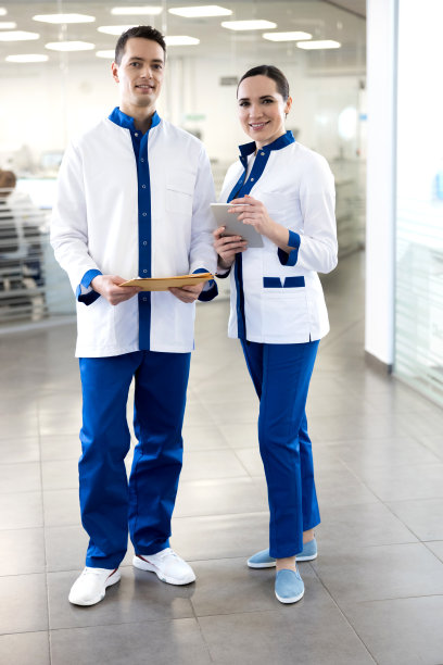 微笑的医生和他迷人的女同事站在诊所图片下载