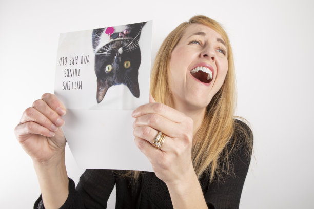 女人在看有趣的贺卡时大笑图片下载