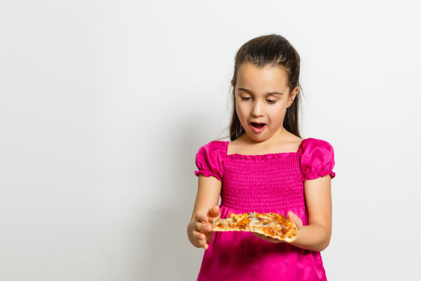 印度亚洲可爱女童吃盒装披萨，白色背景图片下载