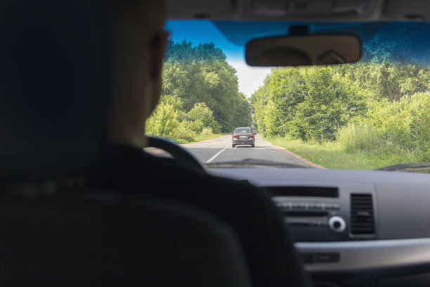 后视图和后视图的司机后车轮的汽车和前面的道路图片下载