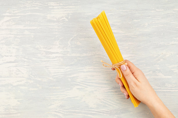 平铺的女人手拿意大利面煮意大利面。俯视图的传统意大利美食图片下载