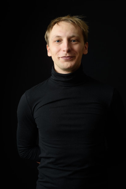 身穿黑色衬衫，背景为黑色的果断英俊男子肖像图片下载