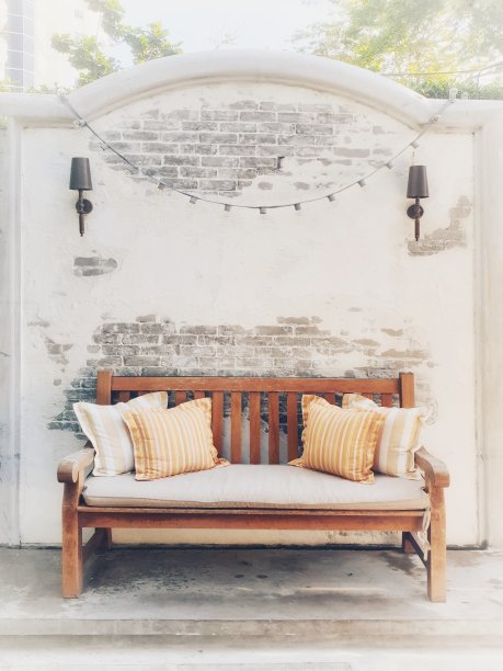 木制的沙发椅，奶油色的泡沫座椅和橙色的枕头图片下载