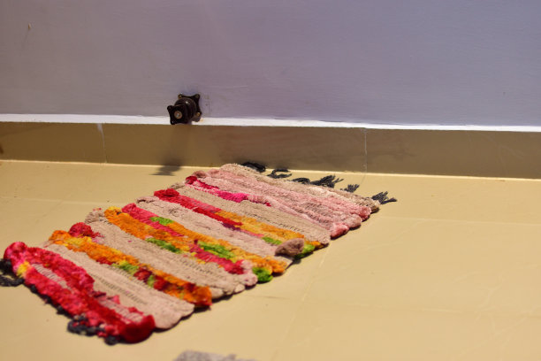 旧的多色酒店门垫在石头地板上。房间门口的节日欢迎垫。图片下载