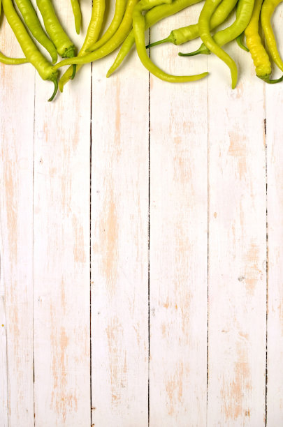山羊角热青椒辣椒上部框架在乡村木制白色背景。前视图。副本的空间。垂直的照片。图片下载