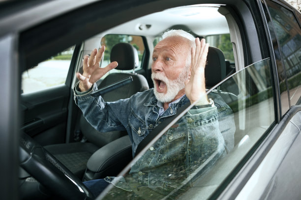 老人坐在车里开车，意外的把智能手机丢在了车里，不顾一切的开车就要撞车了图片下载