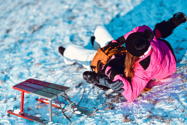 男孩和女孩滑下坡后从雪橇上摔下来图片下载