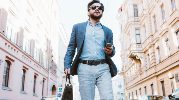 在城市街道上匆忙行走的年轻英俊商务男士图片下载