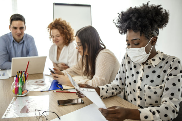 戴医用口罩在商务办公室工作的员工图片下载