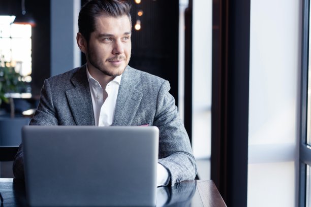 全神贯注：身穿西装的年轻男人在咖啡馆使用电脑图片下载