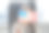 一名年轻女子手握美国国旗，坐在办公室桌子旁的扶手椅上图片下载