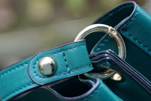 绿色皮革背带袋与黄色金属铆钉图片下载