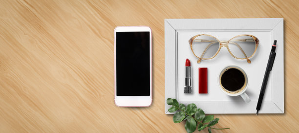 女性平躺着，拿着智能手机、口红、眼镜、咖啡和一支笔图片下载