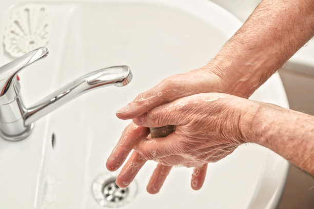 老人用手蘸肥皂，水龙头下的水，细节照片。在新型冠状病毒/冠状病毒19疫情预防中，是否可以作为卫生说明概念图片下载