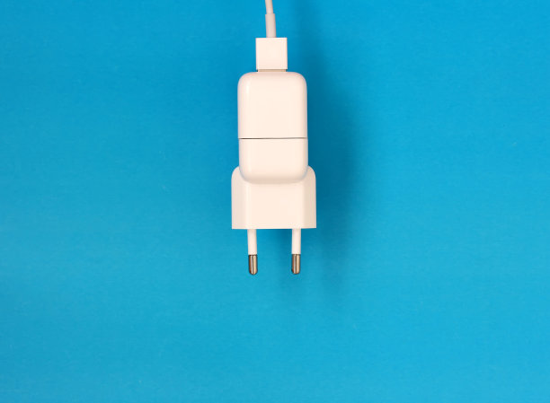 蓝色背景上的白色手机充电器。图片下载
