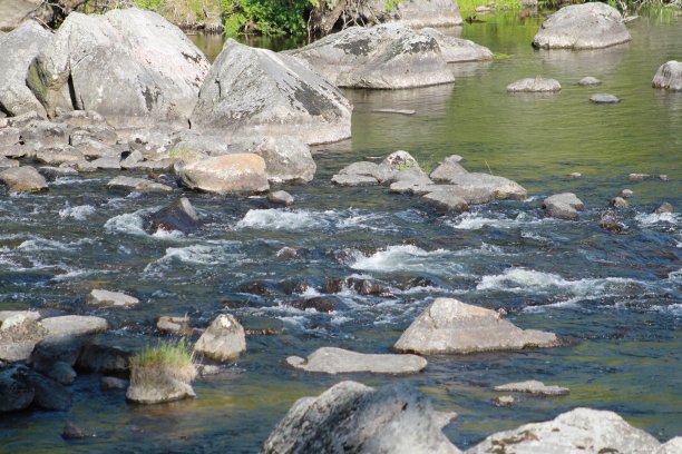 水从岩石坡上流下，流进平静的湖里图片下载