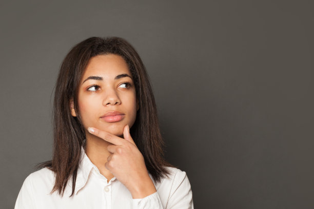 在灰色背景上思考的聪明的黑人女性图片下载