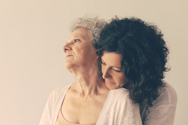 平静沉思的成年女儿拥抱年长的母亲图片下载
