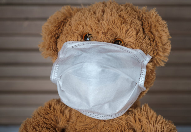 一只带着医用口罩的泰迪熊正坐在家里。冠状病毒大流行的传播概念和家庭隔离图片下载