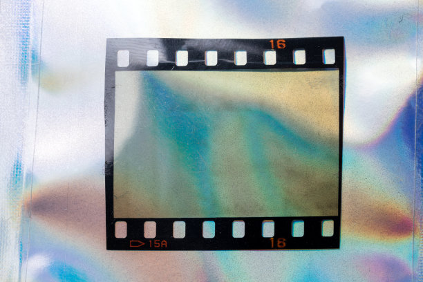 高分辨率的微距照片单35毫米幻灯片上的抽象彩色彩虹全息箔背景与光泄漏。图片下载