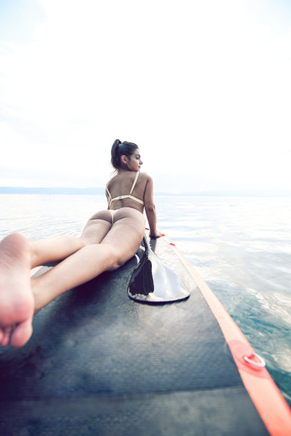 可爱的女性躺在桨板上图片下载