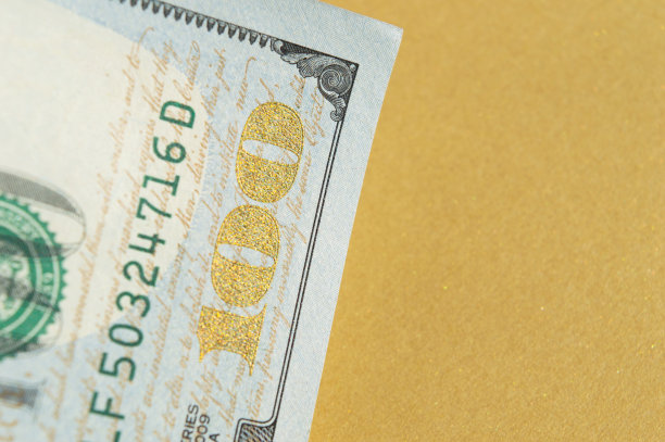 一张100美元的纸币在左上角的金色背景上。概念照片，简约设计图片下载