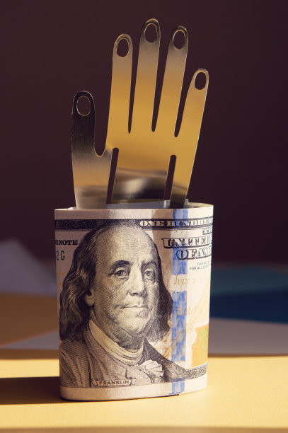 美元，用金属的手握在金色和黑色的背景上。概念照片，简约设计图片下载