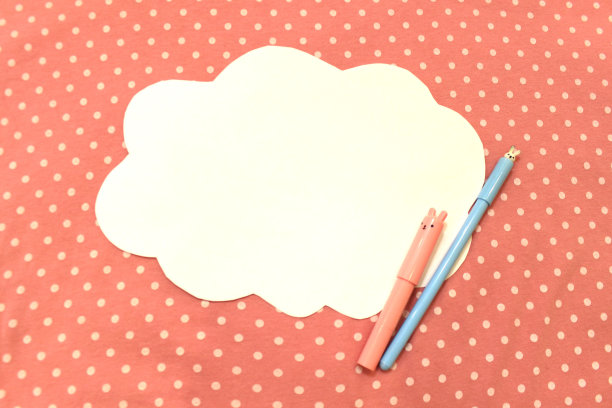 在粉红色圆点布料上的云朵形状的白纸照片。背景文字，问候，邀请，节日，复活节。彩色抽象模型模板与钢笔铅笔标记花郁金香图片下载