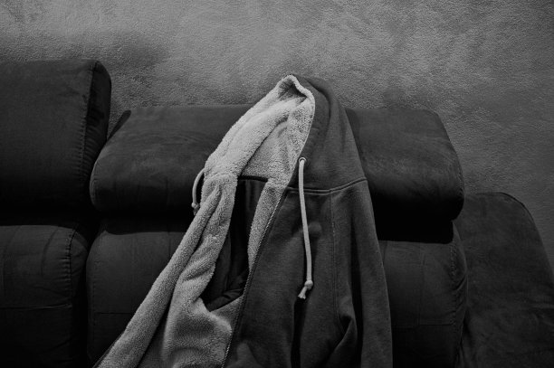 带皮草和兜帽的孤立毛衣放在沙发上(意大利，欧洲)图片下载