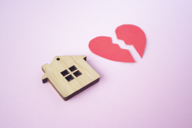 离婚，财产分割，贫穷和无钱的概念。带着破碎的心的木头房子在明亮的粉红色背景上。抵押贷款、租赁、房地产经纪人图片下载