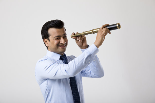 商务人士用单筒望远镜观察图片下载