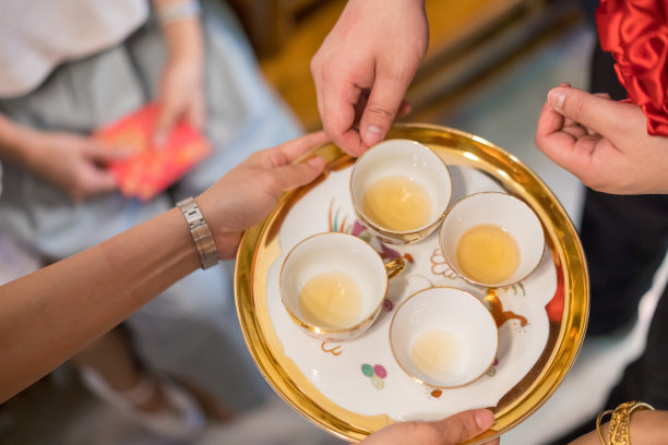 新婚夫妇在中国传统茶道上给老人斟茶图片下载