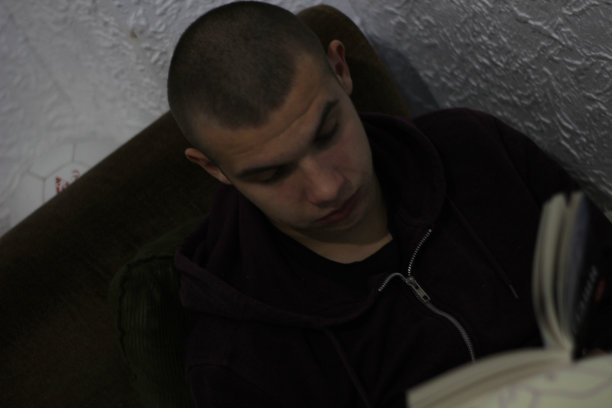 男孩在床上看书。图片下载