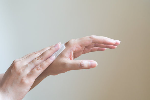 一个女人正在用白色的软纸巾擦手。孤立在白色背景上图片下载