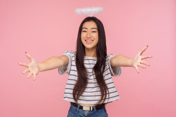 迷人的天使亚洲女孩的肖像与长黑发和头顶的光环打开她的双手广泛拥抱图片下载